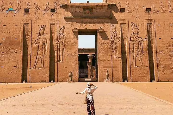 Visitor facing the massive Edfu Temple entrance on a private Luxor tour from Cairo by air, Egypt
