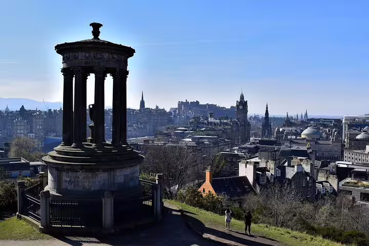 Panoramic view of Edinburgh city skyline from Calton Hill, showcasing historic architecture on a sunny day during a 2-hour highlights tour.