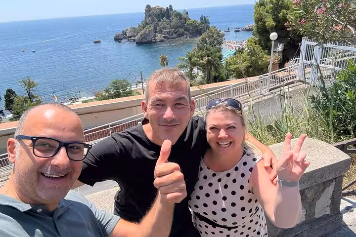 Smiling travelers selfie on sunny Mediterranean coast viewpoint, not related to Glencoe and Highlands tour