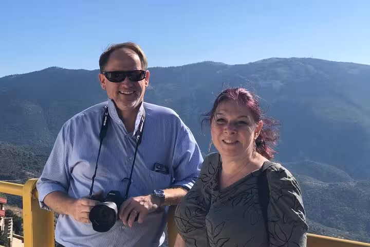 Happy travelers with camera enjoying panoramic Highland mountains on the Glencoe and Highlands Adventure tour