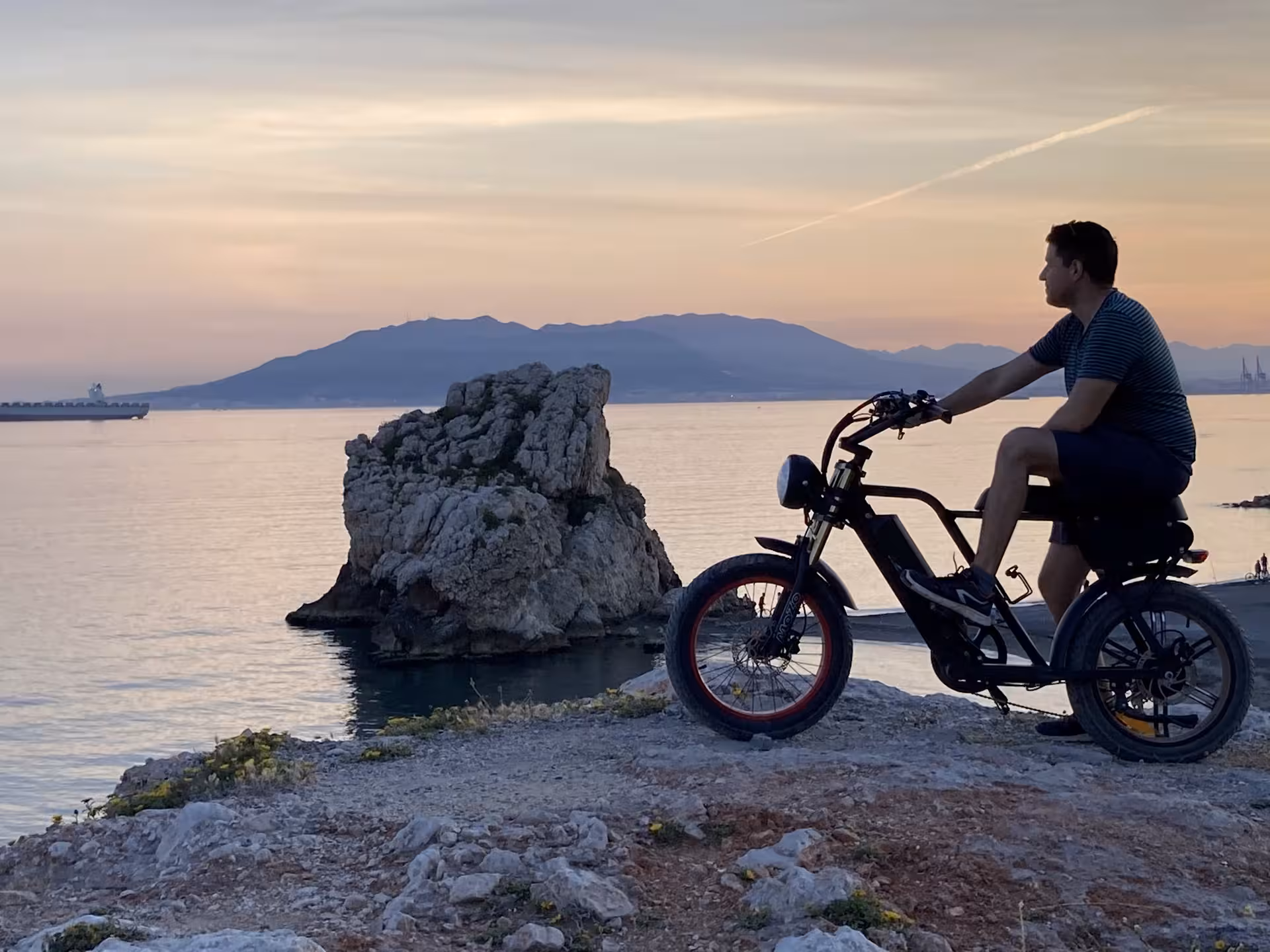 Rider on e-fat bike at sunset by the sea, perfect for a 4-hour coastal views e-bike rental adventure