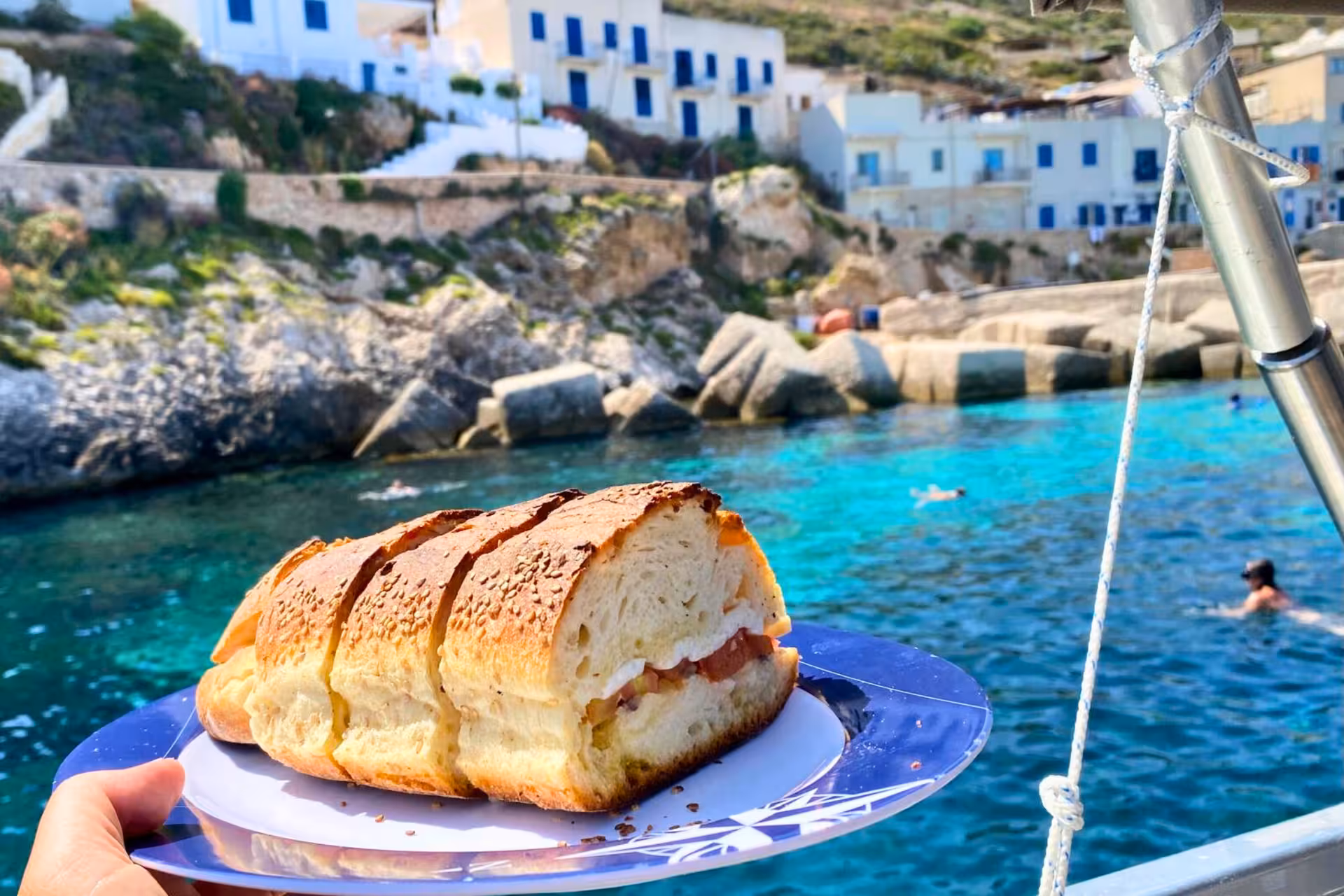 Boat lunch sandwich in turquoise cove at Favignana on Egadi Islands private tour from Trapani