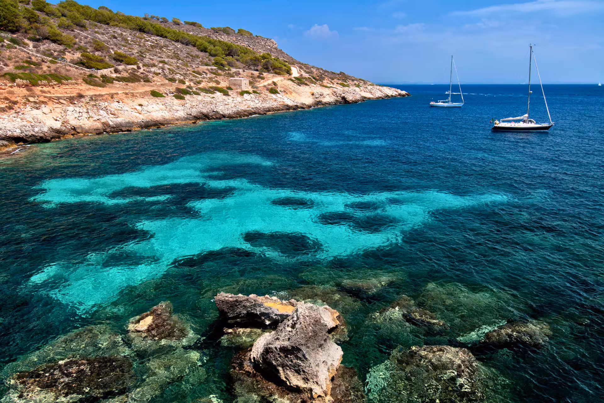 Turquoise cove in Favignana with sailboats, scenic stop on Egadi Islands boat tour from Trapani with lunch