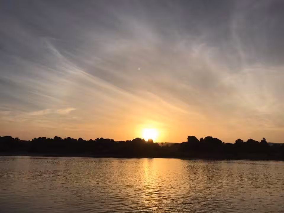 Sunset over the Nile River in Egypt, serene waters on an Egypt Explorer felucca cruise adventure