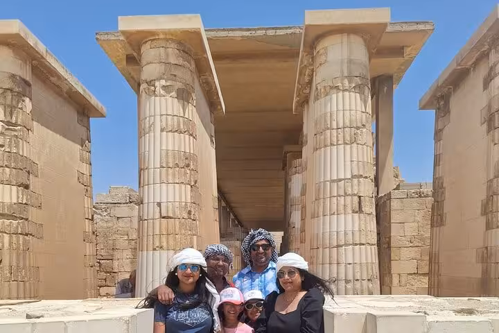 Tourists exploring ancient Egyptian columns under a clear blue sky during an 11-day Nile cruise tour.