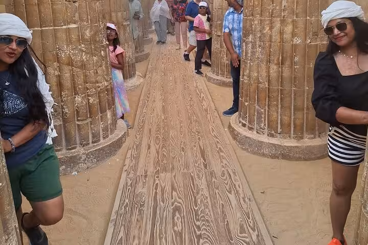 Visitors walking between historic Egyptian columns on a guided tour along the Nile, showcasing rich cultural heritage.
