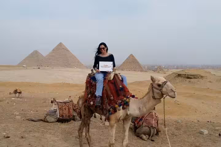 Traveler on camel with Giza Pyramids backdrop, classic desert experience on 6-day Egypt tours package