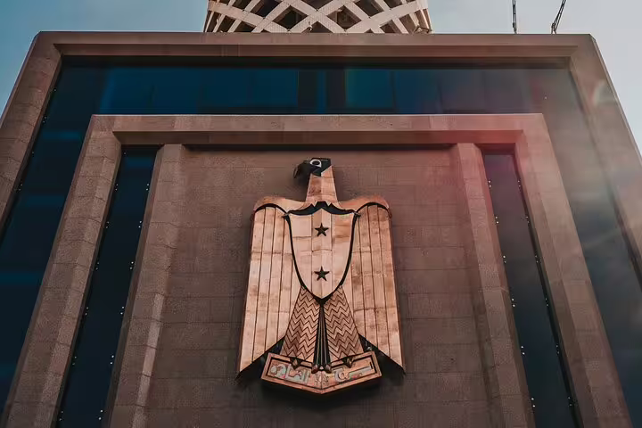 Egyptian eagle emblem on a modern facade near Cairo Tower, featured on the El-Moez Street city tour