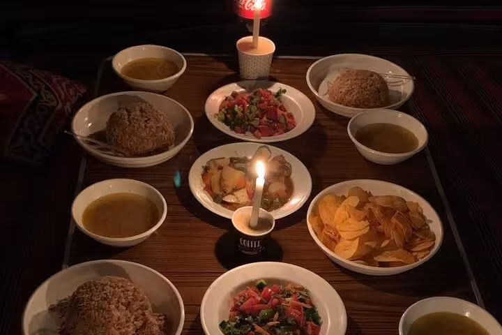 Candlelit Egyptian food spread with rice, salads, chips and mint tea on a traditional local tour