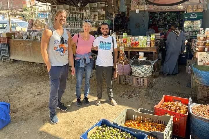 Guests with local guide at Cairo market stall, sampling Egyptian snacks and tea on a food tour