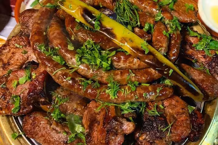 Close-up of grilled Egyptian kofta and sausages with herbs and chili, a highlight of a Cairo food tour