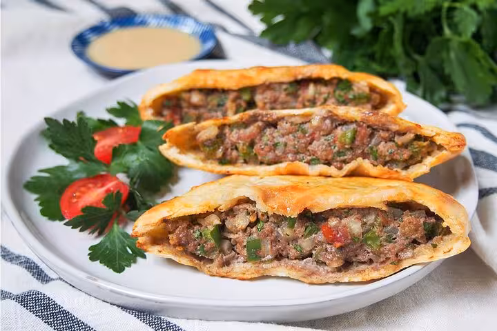 Plate of freshly baked Egyptian meat pies with herbs, a savory delight on the Cairo food tour.