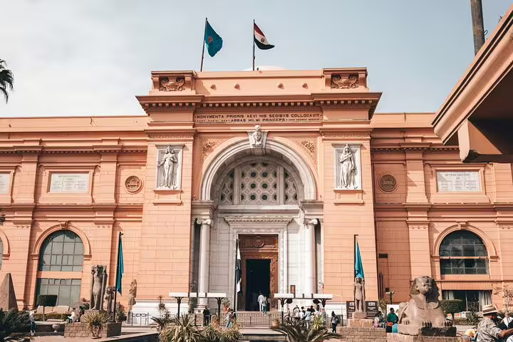 Egyptian Museum Cairo entrance with flags and statues, popular stop on Giza Pyramids, Citadel and bazaar tour