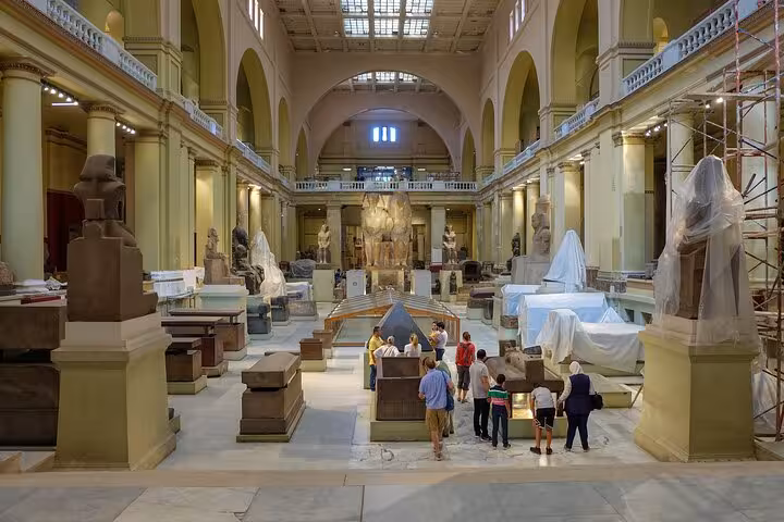 Grand hall of the Egyptian Museum Cairo with statues and visitors on a private guided tour