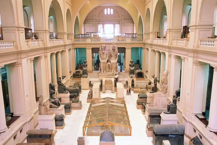 Grand hall of the Egyptian Museum Cairo with colossal statues and ancient artifacts on a day tour