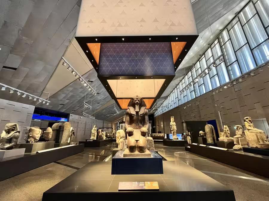 Egyptian Museum gallery with colossal pharaoh statue and ancient artifacts, included in private 4-day Cairo tour