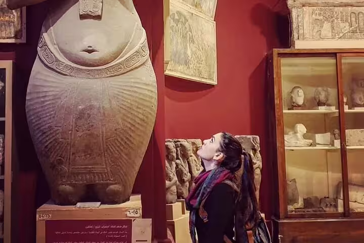 Traveler admiring ancient Egyptian sarcophagus on private half day guided tour inside the Egyptian Museum Cairo
