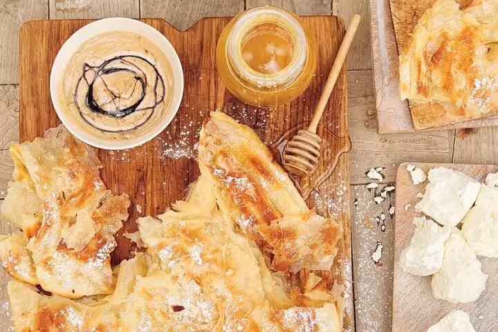Assorted Egyptian pastries with honey and tahini sauce, highlighting delicious flavors on the Cairo food tour.