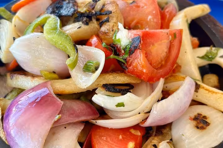 Enjoy a vibrant Egyptian salad with fresh tomatoes, onions, and peppers during your private pyramid tour.