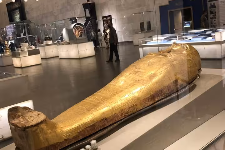Golden ancient Egyptian sarcophagus on display at the Grand Egyptian Museum on a private Giza tour