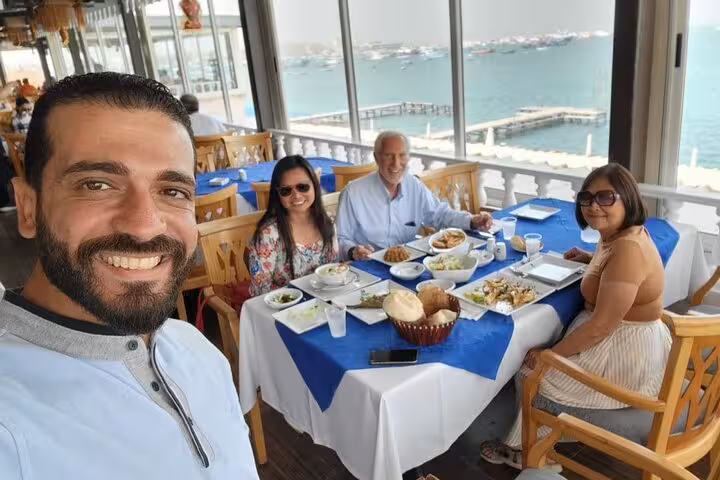 Group enjoying Egyptian seafood lunch by the Alexandria seafront, part of an eat-like-a-local food tour