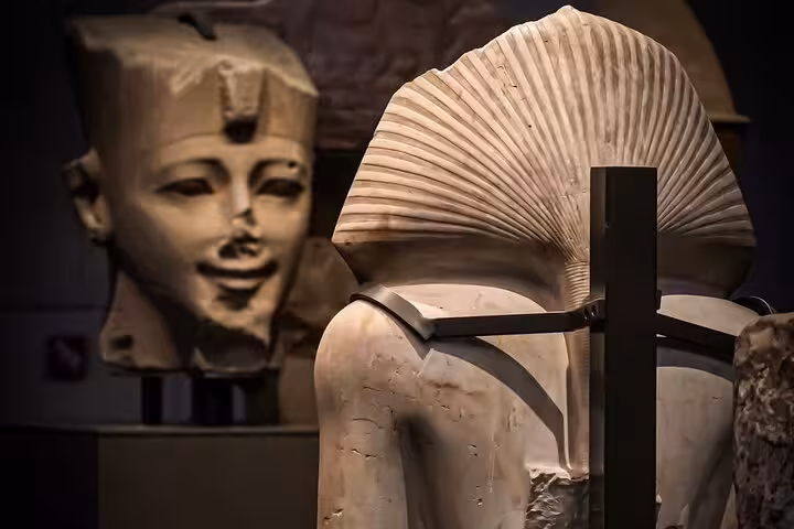 Ancient Egyptian statue and pharaoh head on display at the Grand Egyptian Museum on a private Giza tour