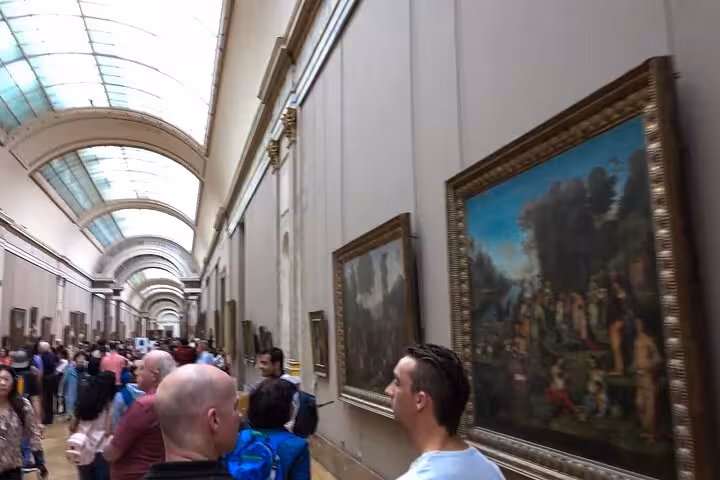 Crowded Louvre corridor with masterpieces on private Paris tour including Seine cruise and Eiffel Tower lunch