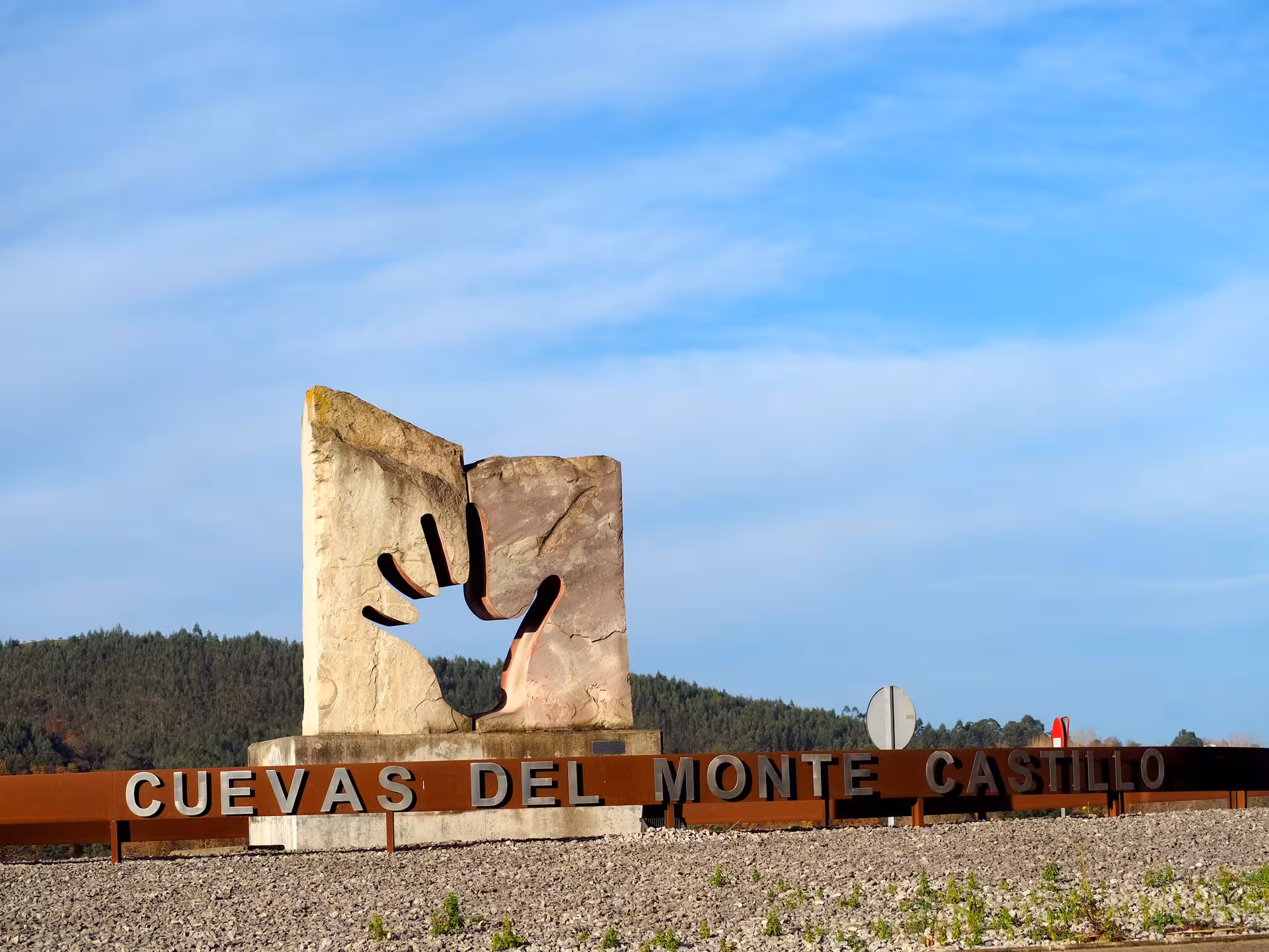 Entrance sculpture at Cuevas del Monte Castillo, marking the start of the historic caves and rock art tour in Spain.