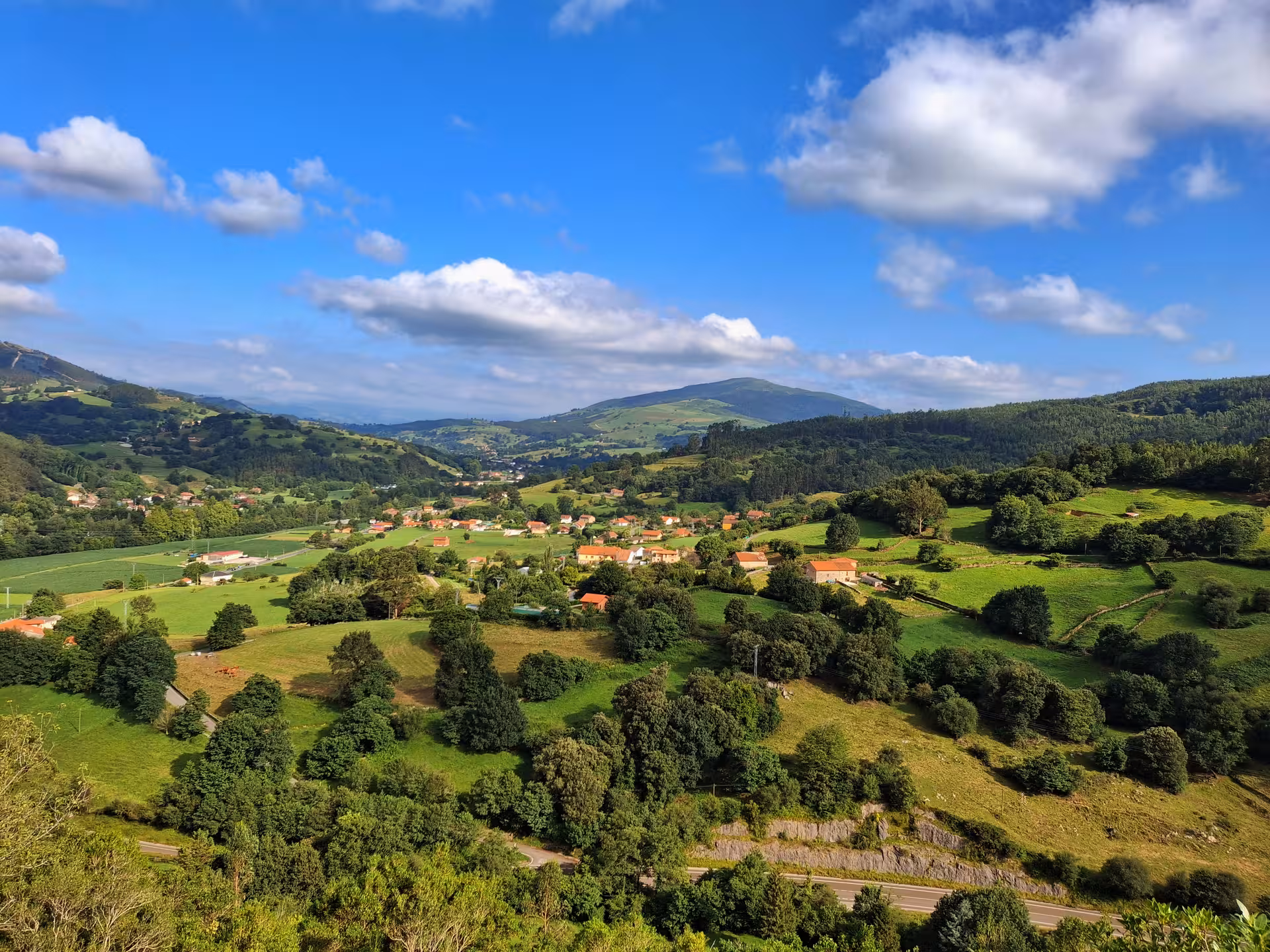 Scenic view of lush green valleys and distant mountains near El Castillo Caves, ideal for nature exploration tours.