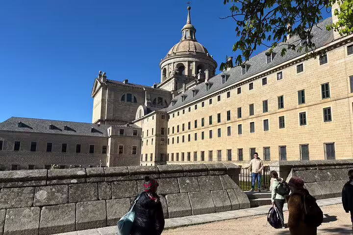 El Escorial basilica dome and palace facade with tourists on a private minivan day trip from Madrid