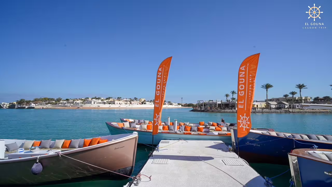 El Gouna lagoon tour boats at marina with orange flags, Red Sea city tour and scenic cruise in Egypt