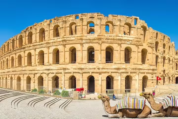 Discover the grandeur of the El Jem Amphitheatre with camels in the foreground on your Tunisia tour adventure.
