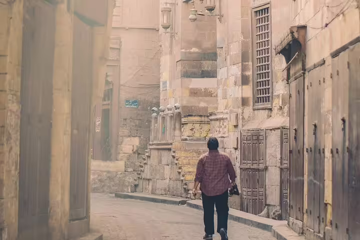 Traveler walking through Old Cairo alley on El Moez Street, part of a 4-hour bazaar and heritage tour