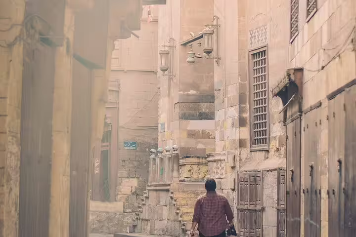 Traveler walking a historic alley on El-Moez Street, Islamic Cairo old town on Cairo Tower tour