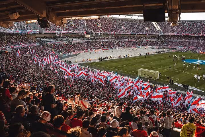 Packed El Monumental stadium with River Plate flags during a Buenos Aires matchday experience with a local