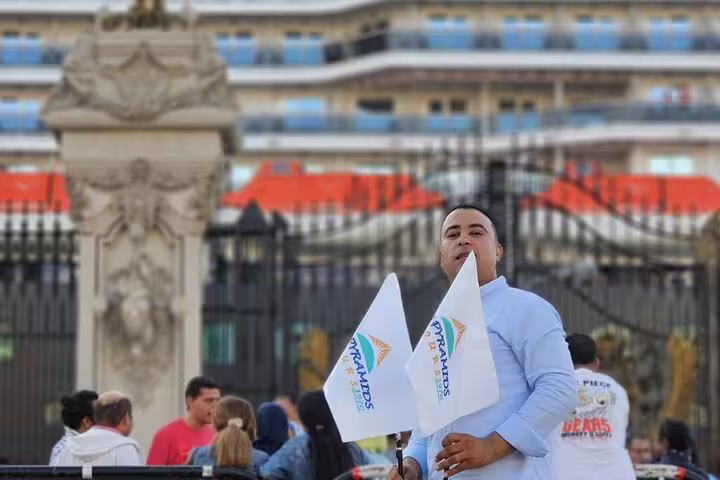 Private tour representative holding flags at El Sokhna Port pickup point for Sakkara Pyramids desert safari excursion