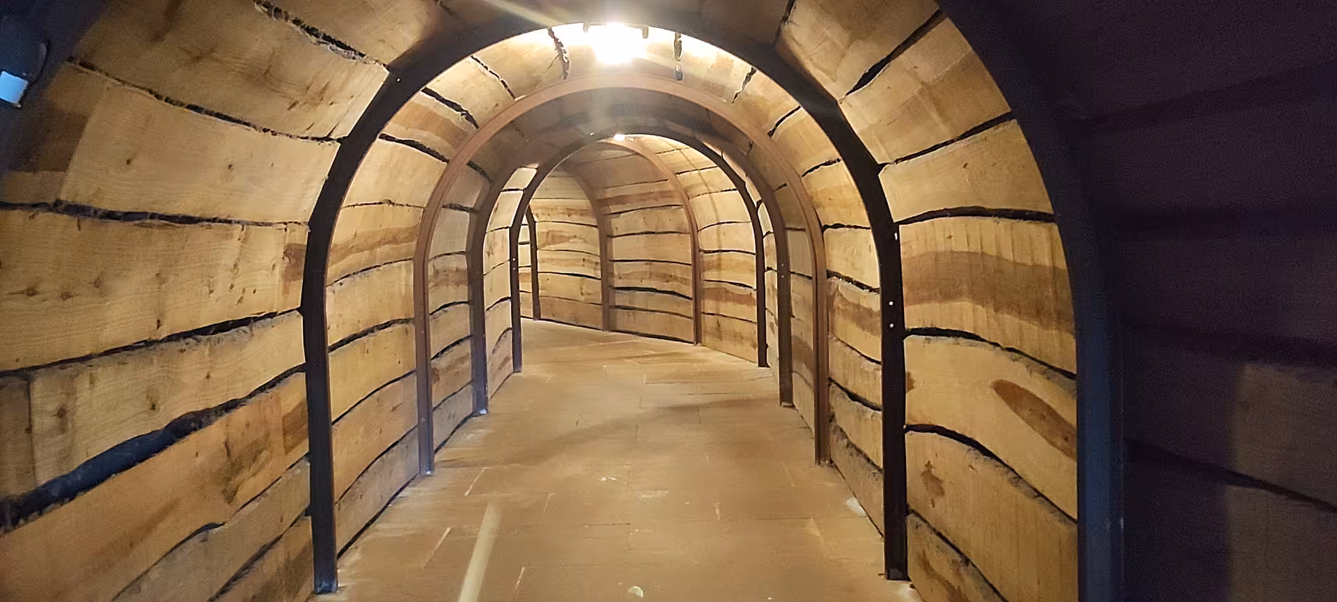 Wooden tunnel entrance leading into El Soplao Cave, part of the guided tour from Santander and Torrelavega.