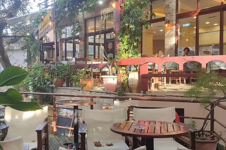 Relax at a charming outdoor cafe surrounded by greenery on the Private Tour Elafonisi Beach with Honey Olive Oil & Wine Tastings.