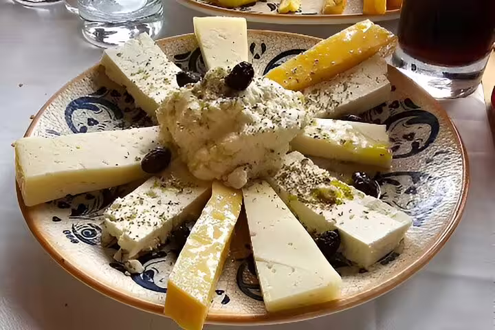 Plate of assorted local cheeses garnished with herbs and olives, part of the Elafonisi Beach tour tasting experience.