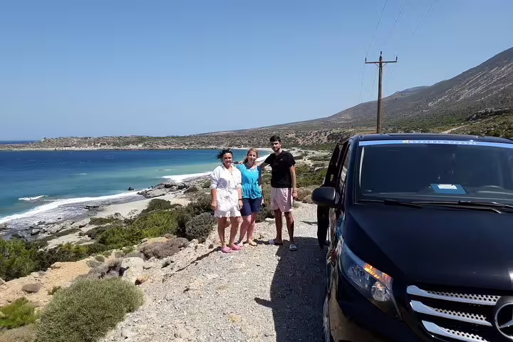 Group enjoying scenic view of Elafonisi Beach during private tour from Chania, featuring vibrant blue waters and pink sands.