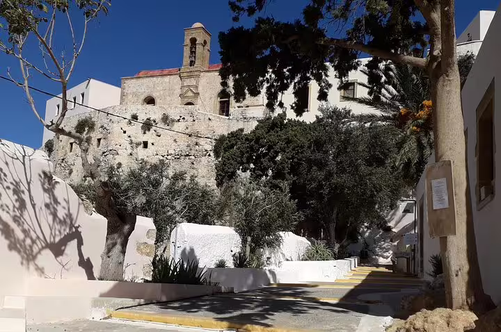 Historic stone architecture and lush greenery in a charming alleyway near Elafonisi Beach, Crete, on a private Chania tour.