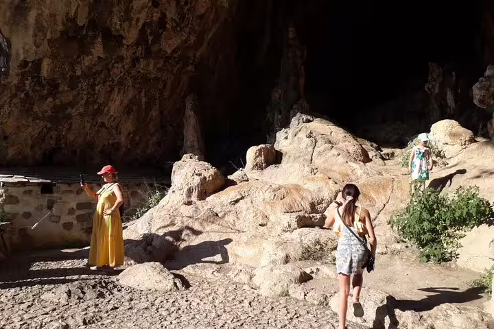Tourists explore a rocky cave near Elafonissi Beach, showcasing the natural beauty and adventure of a private tour.
