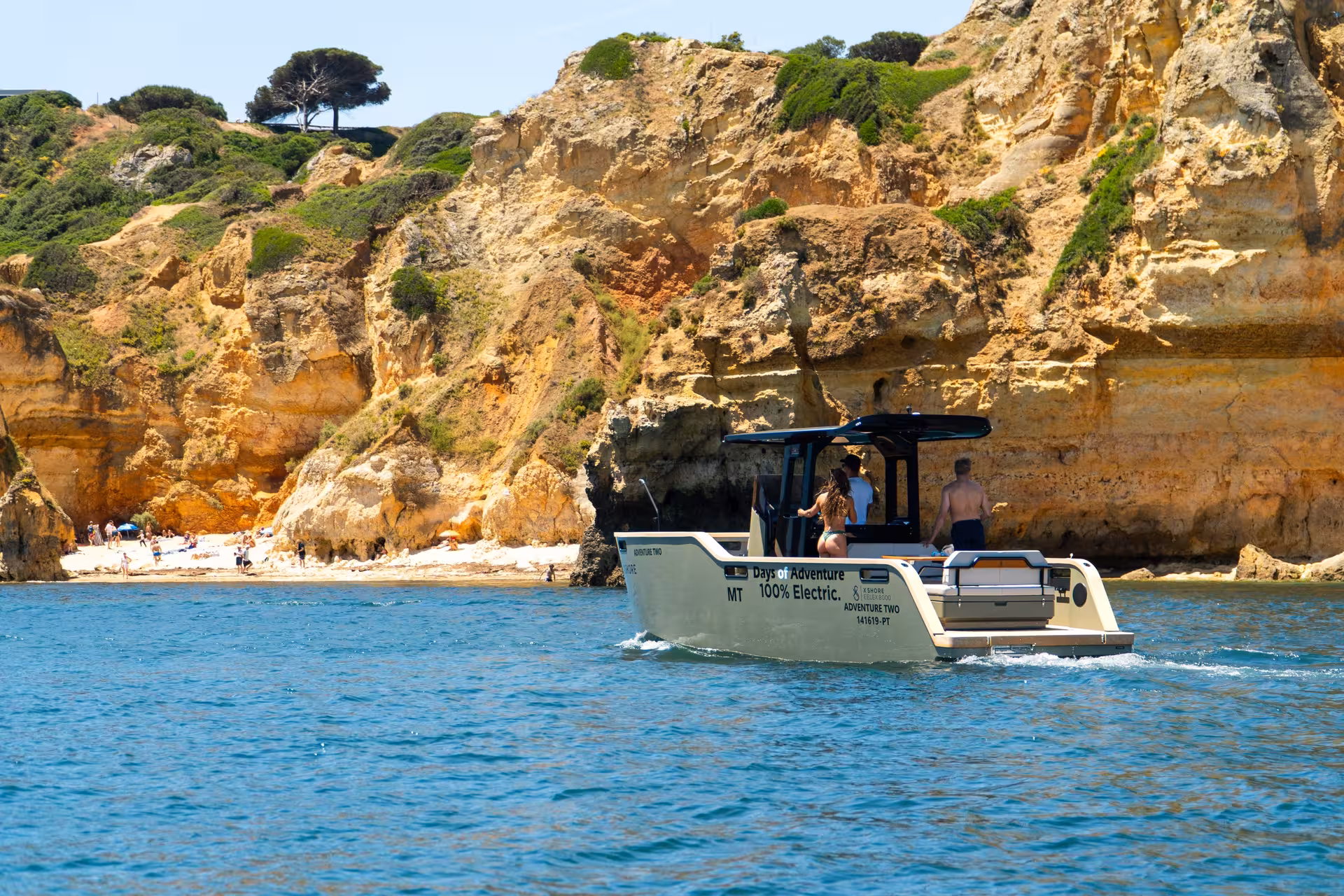 100% electric private boat tour cruising past golden limestone cliffs and sandy beach at Ponta da Piedade Lagos Algarve