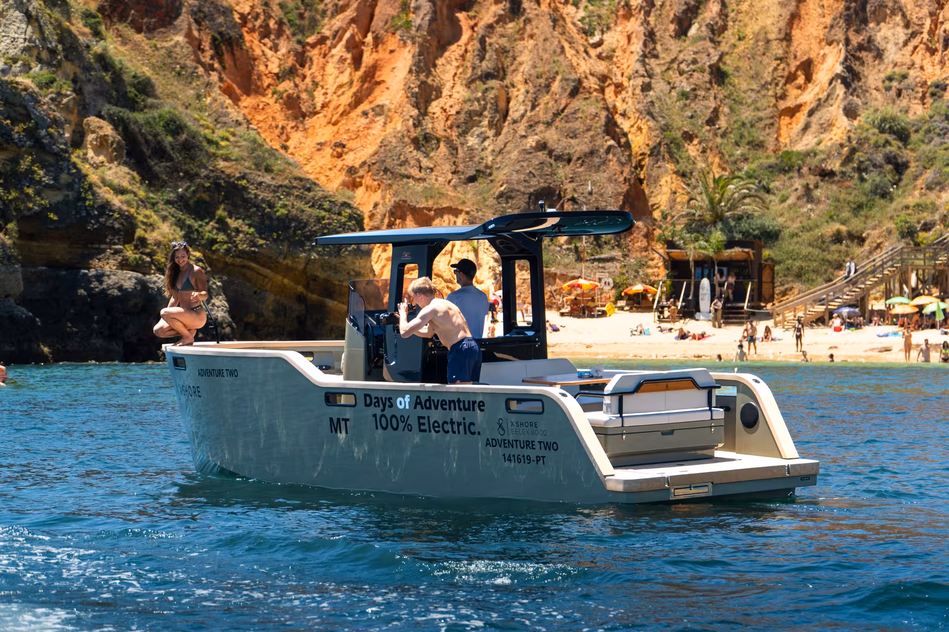 Guests aboard a 100% electric private tour boat near Ponta da Piedade stunning red cliffs and beach in Lagos Algarve