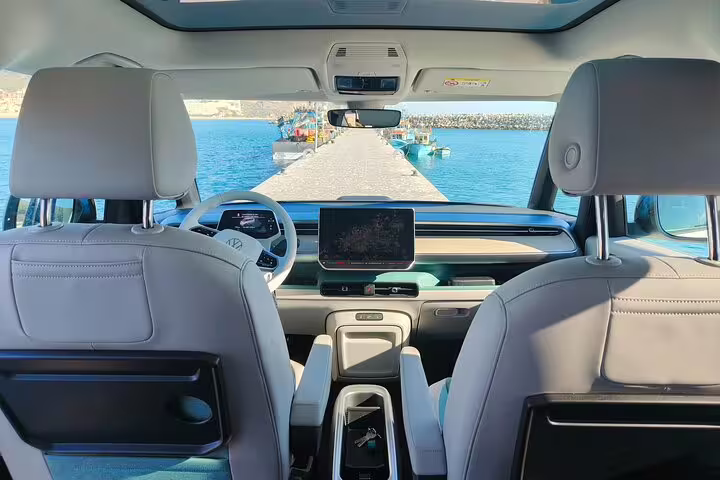 Interior view of an Electric ID Buzz with a stunning ocean pier backdrop on a Lisbon to Sesimbra trip.