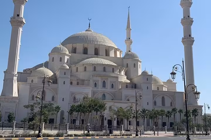 Grand white mosque with domes and minarets, a key stop on Emirates UAE culture and heritage attractions tour