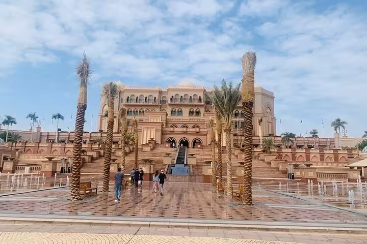 Emirates Palace Abu Dhabi entrance with palm-lined walkway, key stop on private multilingual city tour