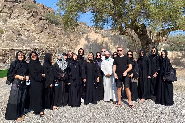 Tour group in traditional attire at historic mountain village, UAE culture and heritage guided Emirates tour