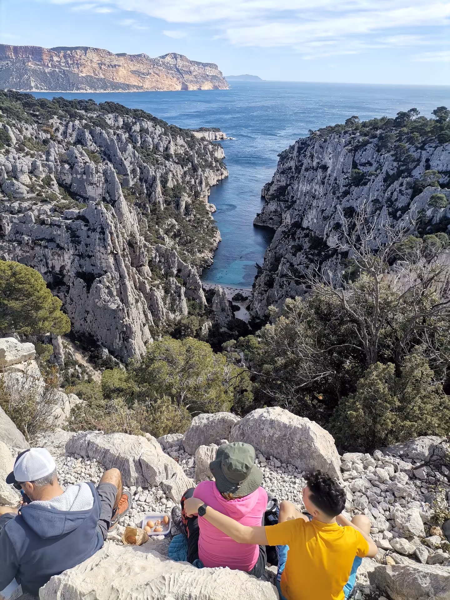 Hikers resting at En-Vau viewpoint above the fjord-like calanque on a Calanques National Park hiking tour from Cassis