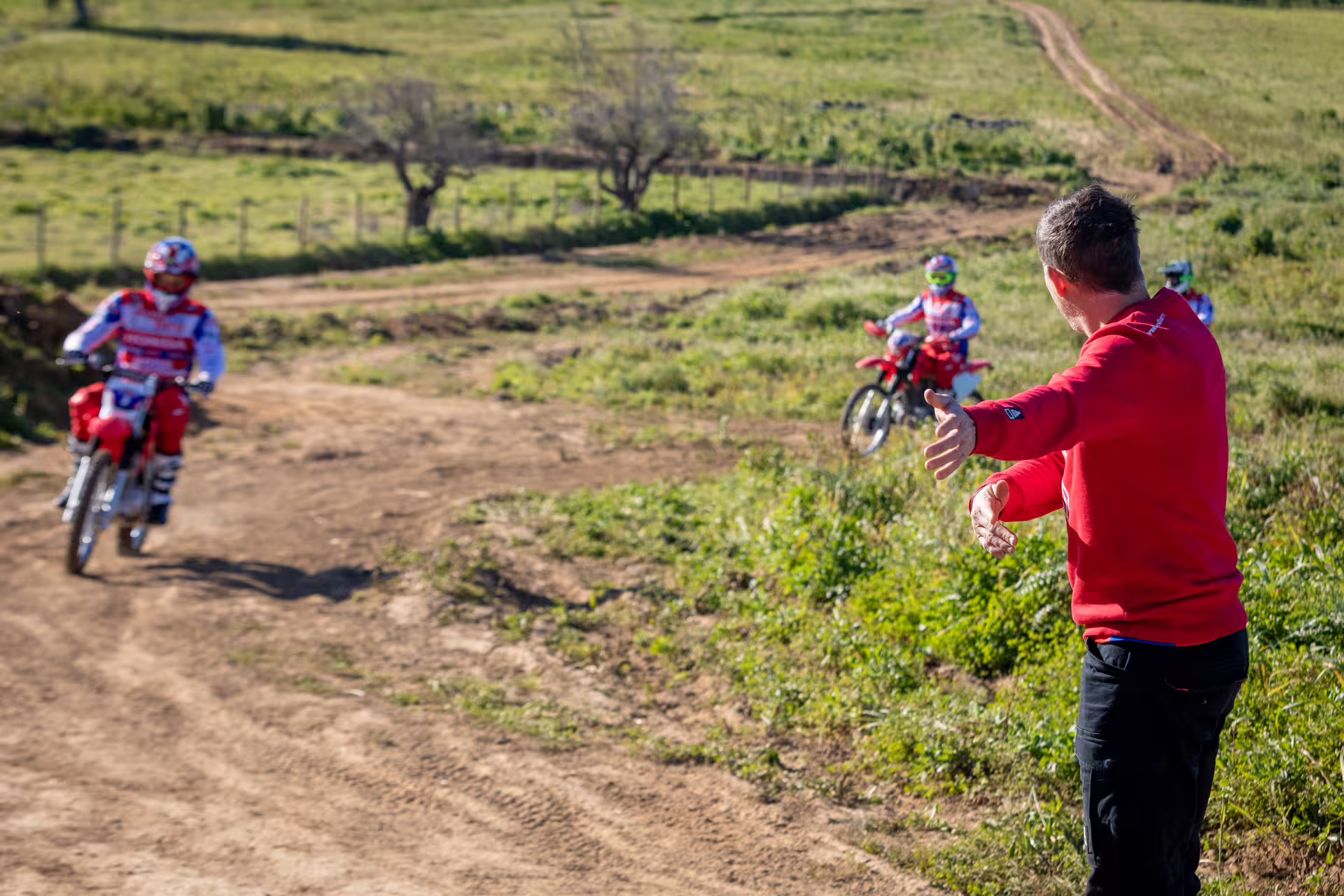 Instructor guiding riders on dirt bikes during First Ride Enduro Experience in Carregado, Lisbon, amidst scenic trails.
